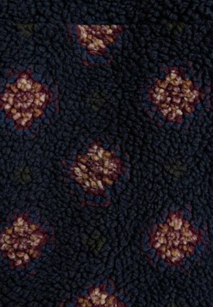 Dunkelblauer Stoff mit einer strukturierten Oberfläche und einem Blumenmuster in Burgund, Creme und Grün. Weiches, samtiges Material.