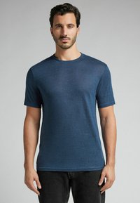 Námořnické tričko s krátkým rukávem a kulatým výstřihem, strukturovaná látka, úzký střih a jemný tkaný vzor, spárováno s černými džíny.