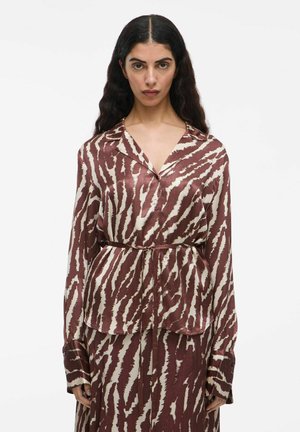 Chemise en soie à motifs marron et crème avec col, manches longues, fermeture à boutons et ceinture à la taille. Remarquable par sa texture lisse et son design fluide.