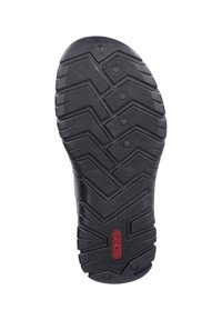 Semelle de chaussure en caoutchouc noir avec un motif de crampons en zigzag, un design de traction circulaire et un accent de logo rouge près du talon. Taille marquée comme 41.