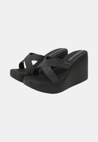Sandali con zeppa caratterizzati da un design a strappo incrociato glitterato nero, una superficie liscia e una suola piatta spessa, con una soletta firmata.