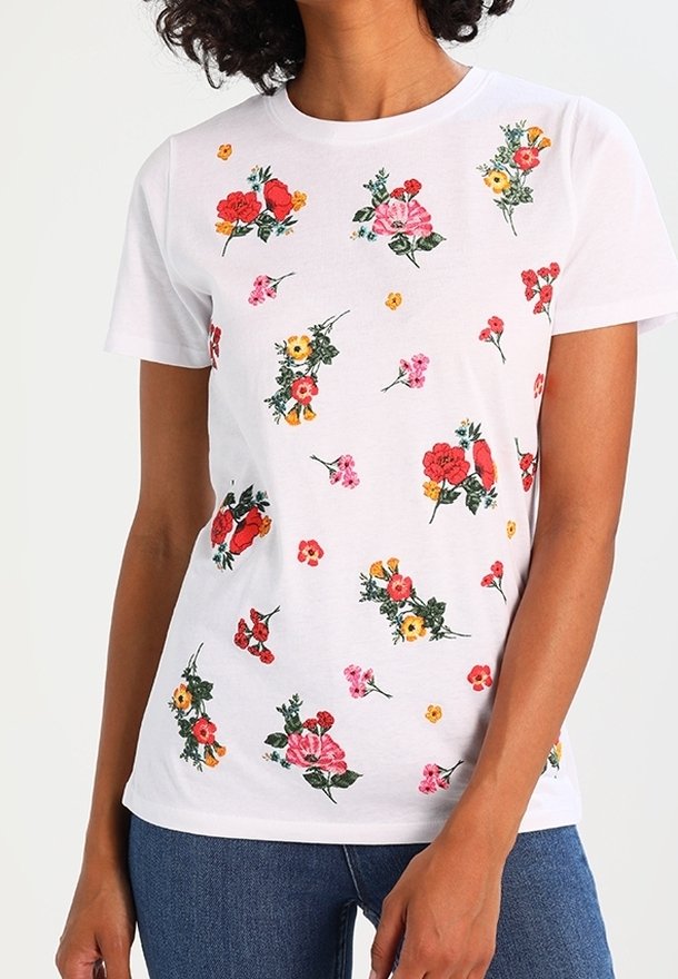 Hvid kortærmet t-shirt med et blomsterprint i rød, pink, gul og grøn. Blødt stof med flere broderede blomster overalt.