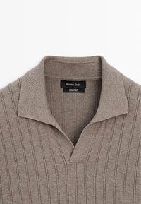 Brun ribstrikket polo med kort krave, åben V-hals og Massimo Dutti-mærke. Fremstillet af 100% bomuld.