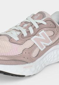 Ροζ και λευκό παπούτσι New Balance με επάνω μέρος από δίχτυ και δέρμα, λευκά κορδόνια και υφασμένο λευκό πέλμα Fresh Foam.