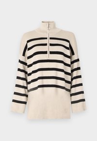 Cream-colored cropped sweater with black horizontal stripes, high collar, and half-zip closure. Textured fabric with wide sleeves.