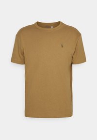 Hnědé bavlněné tričko s kulatým výstřihem, krátkými rukávy a malým zeleným logem na levé straně hrudi. Hladká textura a klasický střih.