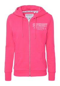 Rosa Reißverschluss-Hoodie aus weichem Material. Verfügt über eine Kängurutasche, eine Kapuze mit Kordelzug und ein weiß bedrucktes Logo auf der Brust.