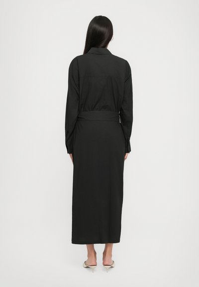 Black long-sleeve dress with a collar, tailored fit, belted waist, and a straight hem. Smooth fabric texture and buttoned cuffs.