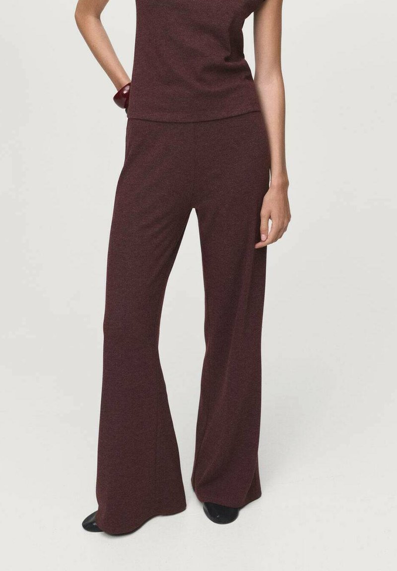 Ensemble bordeaux deux pièces comprenant un haut ajusté et un pantalon à jambes larges, confectionné dans un tissu doux et texturé. Design simple sans motifs ni accents.