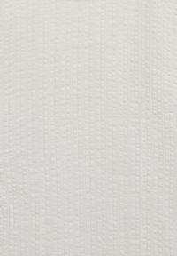 Tissu blanc texturé avec des lignes verticales et de petits points en relief, créant une surface tactile. Répartition uniforme de la couleur sans motifs ou accents visibles.