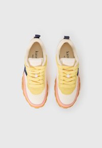 Yellow, pink, and white sneakers with a mesh upper, rubber sole, and laces. Features a navy accent and logo on the insole.