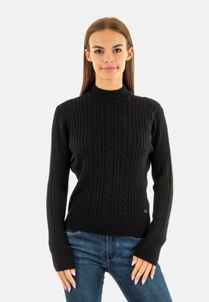 Pull en tricot noir avec une texture côtelée et un col montant. Manches longues avec des poignets ajustés. Subtiles motifs en chevrons sur l'ensemble.