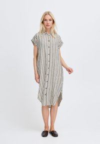 Randig knapplång klänning i beige och marinblå, korta ärmar, avslappnad passform, knä-lång, tillverkad av lätt tyg med en sidslits.