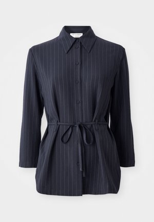 Navy shirt with vertical white stripes, long sleeves, button front, and shirt collar. Features a tied waist for a fitted silhouette.