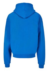 Sininen huppari, jossa on sileä pinta, väljä istuvuus, ribattu hihansuu ja lyhyt helma. Takana on keskisauma hupussa.