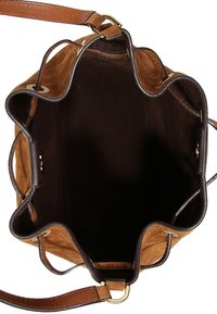 Sac seau en suedine marron avec un bord supérieur festonné, des accents en cuir et un intérieur marron foncé. La sangle est réglable et en cuir.