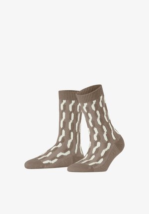 Brown knitted socks featuring a wavy white pattern. Ribbed cuff and soft texture enhance comfort and fit. Mid-calf length design.