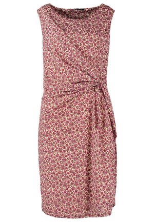 Woman wearing sleeveless red floral dress, black tights, brown ankle boots, and carrying a brown fringe shoulder bag.