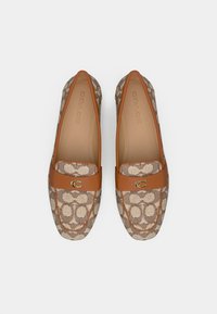 Brown and beige canvas loafers with a signature C pattern, leather trim, and gold-tone hardware. Flat design with rounded toe.
