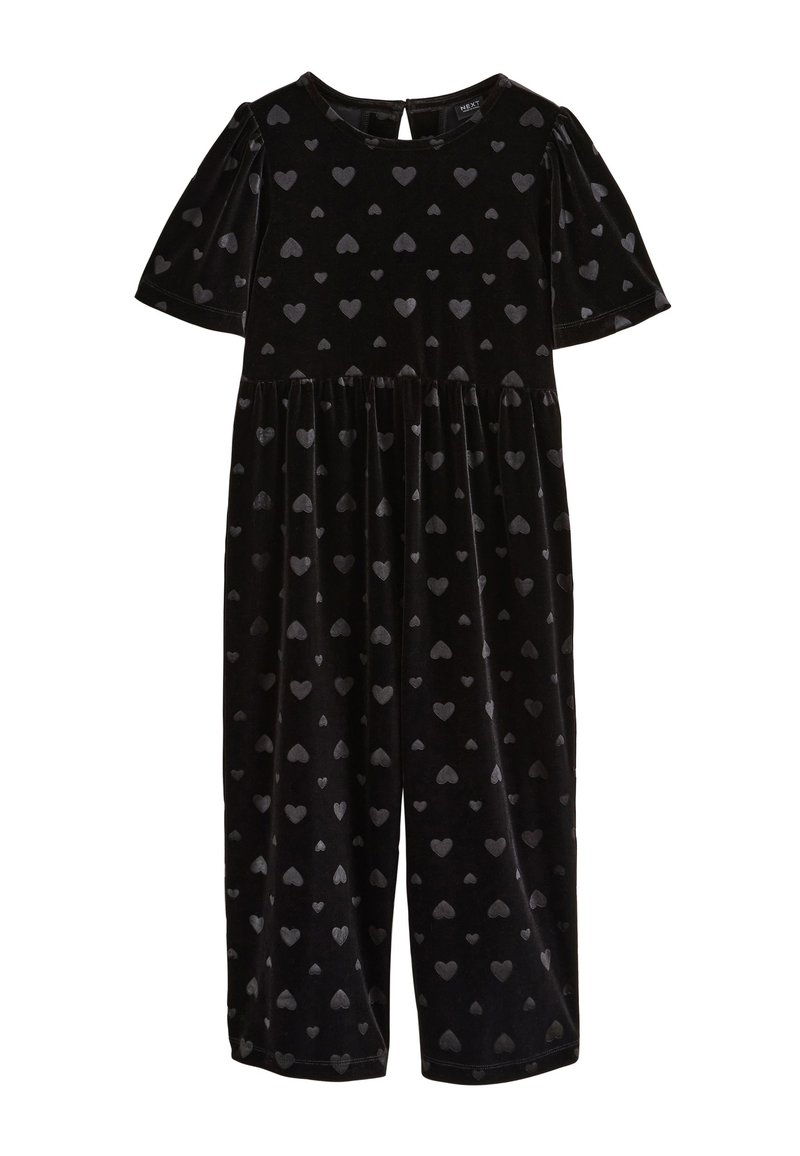 Tuta corta in velluto nero con maniche corte e scollo rotondo, decorata con piccoli motivi a cuore lucidi su tutta la superficie.