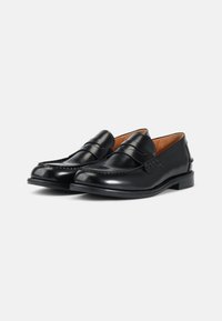 Mustad mustad nahast loafers, millel on sile pind, tikitud detailid ja madal kand. Siseosa on kaetud pruuni voodriga. Klassikaline disain ja kuju.