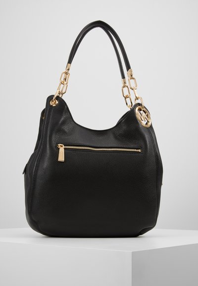 Sac en cuir noir avec une forme décontractée, des accents en métal doré, une poche zippée à l'avant et un charm logo circulaire sur le côté.