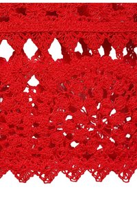 Red lace fabric featuring a floral pattern with raised, rounded details and openwork sections, showcasing intricate stitching and texture.