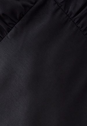 Zwarte stof met een zachte textuur en een lichte glans, met geraffineerde details aan één zijde. Geen duidelijke patronen of hardware zichtbaar.