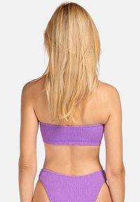 Fioletowy bikini bandeau z teksturowanym wzorem, w komplecie z dopasowanymi spodniami typu high-waisted, zaprojektowane dla zapewnienia stabilnego dopasowania.