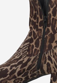 Bottines à imprimé léopard en suède doux, dotées d'une fermeture éclair sur le côté, au design épuré et à la texture mate lisse.