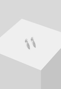 Pendientes de plata en forma de plumas, con un detallado intrincado y una pequeña gema azul sobre cada pluma.