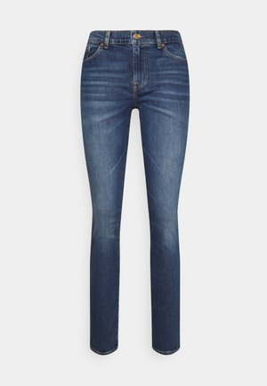 Pantalones vaqueros en azul oscuro con un diseño ajustado, que cuentan con un cierre de botón, estilo de cinco bolsillos y un ligero desgasto en los muslos.