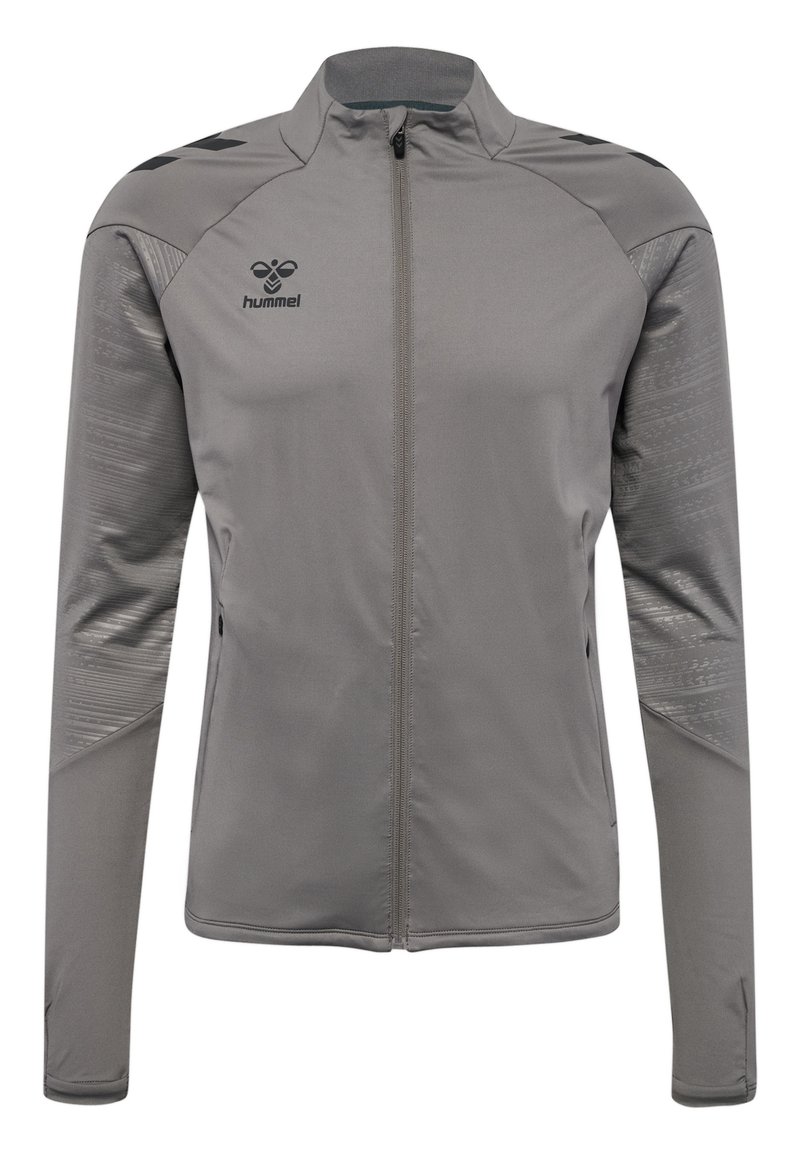 Veste de sport grise en tissu lisse, dotée d'une fermeture éclair pleine longueur, de manches longues et d'accents texturés sur les épaules. Logo Hummel sur la poitrine.