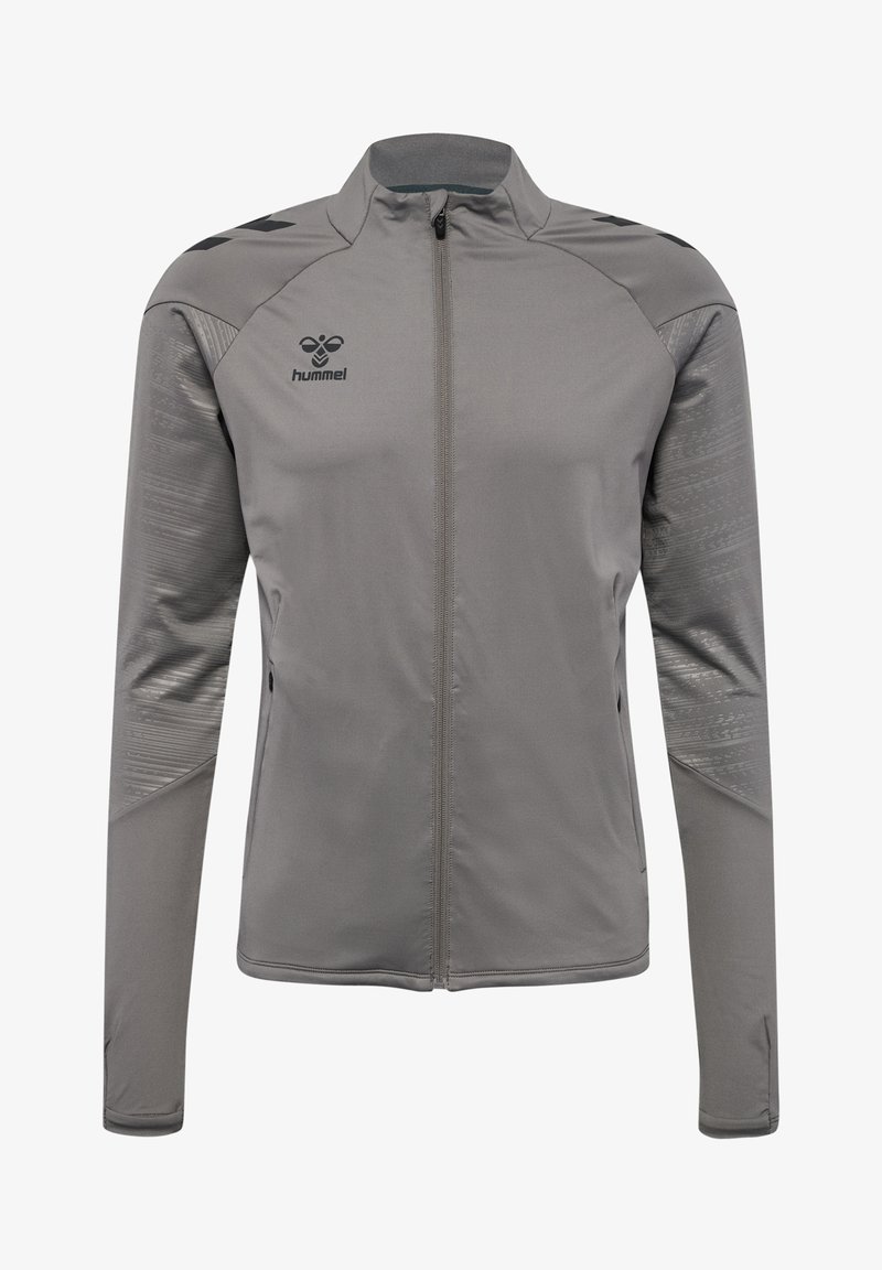 Veste de sport grise en tissu lisse, dotée d'une fermeture éclair pleine longueur, de manches longues et d'accents texturés sur les épaules. Logo Hummel sur la poitrine.