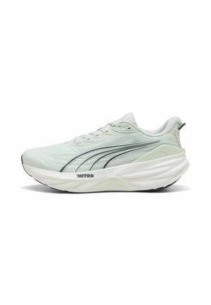 Hellgrüner Laufschuh mit dicker weißer Sohle, schwarzen Puma-Logo-Streifen an den Seiten und dem Text "NITRO" auf der Zwischensohle, von der Außenseite betrachtet.
