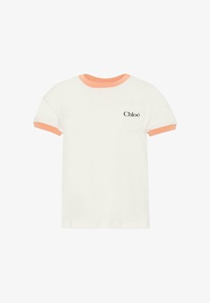 Biała koszulka z krótkim rękawem z pomarańczowym prążkowanym kołnierzem i mankietami rękawów. Posiada małą kieszonkę na piersi z nazwą marki "Chloé" w czerni.