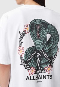 Tricou alb din bumbac, cu un grafic mare de șarpe negru și verde înconjurat de flori, cu textul "ALLSAINTS LONDON" tipărit dedesubt.