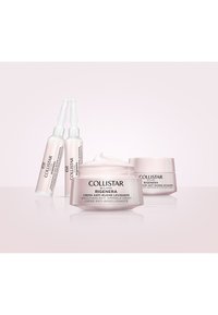 Collistar huidverzorgingsset inclusief een witte crème jar, twee heldere ampullen en een kleine crème jar, met gladde oppervlakken en lichtroze accenten.