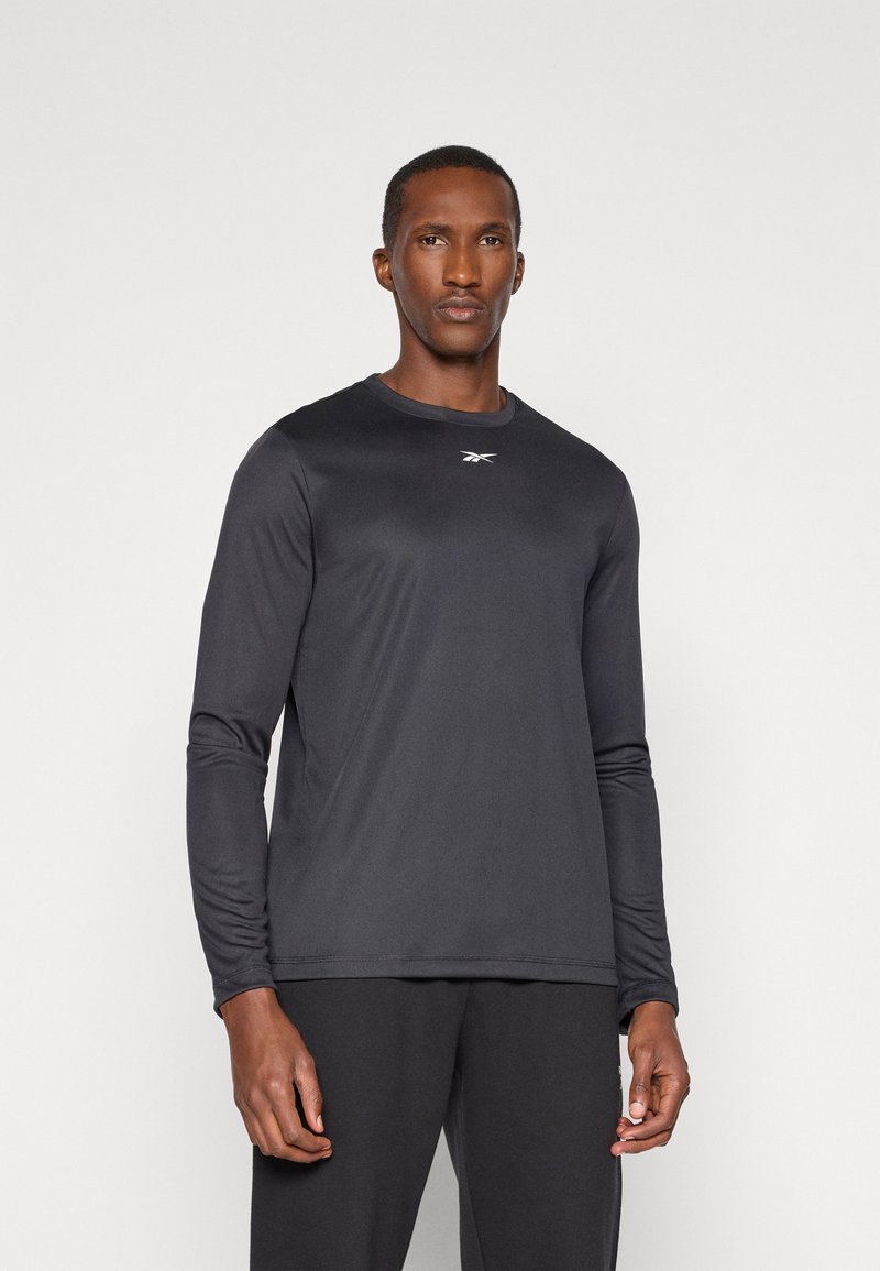 Langärmliges Sportshirt in Schwarz, aus glattem, leichtem Stoff gefertigt. Verfügt über einen Rundhalsausschnitt und ein sichtbares Logo auf der Brust.