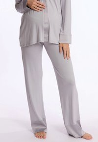 Set de haine confortabile pentru gravide de culoare gri deschis, cu un top larg cu nasturi și mâneci lungi, asortat cu pantaloni drepți, de aceeași culoare.