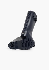 Botín de goma navy con suela texturizada, hebilla lateral ajustable y estrías verticales en la parte superior. Diseño resistente e impermeable.