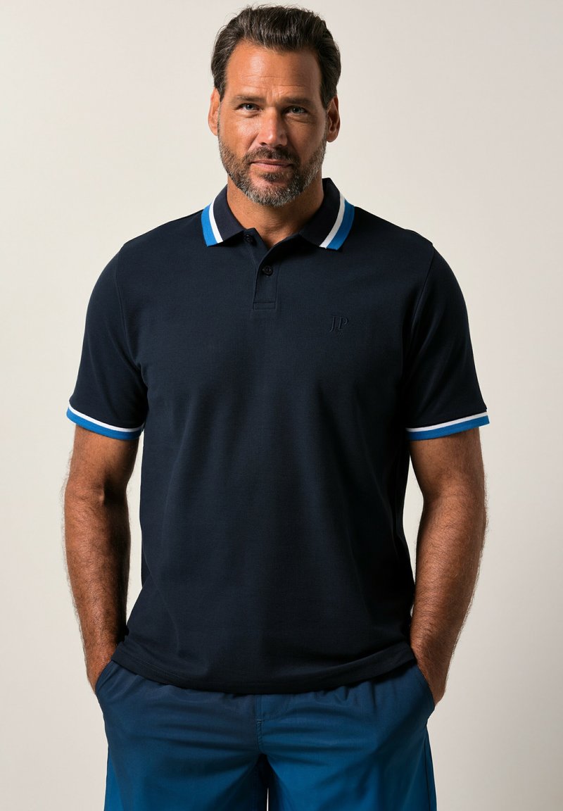 Navy polo shirt with contrasting striped collar and sleeve trim. Features three buttons and a subtle logo on the chest. Made of textured fabric.