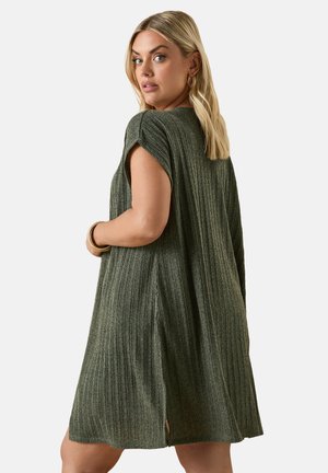 Groene geribde jurk met korte mouwen, voorzien van zijsplitsen en een relaxte pasvorm. Gemaakt van een textuurgebreide stof, geschikt voor casual gebruik.