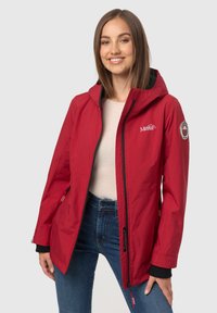 Chaqueta impermeable roja con capucha, con detalles en negro, un logo en el pecho y dos bolsillos laterales. Textura suave y diseño ajustado.