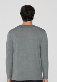 Langärmliges Shirt aus melierter grauer Stoff mit Rundhalsausschnitt und geradem Saum. Einfaches Design ohne sichtbare Muster oder Akzente.