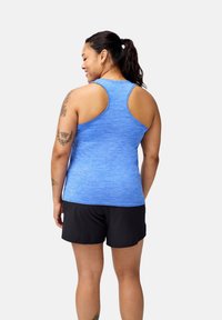 Zils sporta krekls ar sacensību muguras dizainu, izgatavots no teksturēta auduma, kopā ar melniem šortiem. Iezīmējas ar smalku heather rakstu.