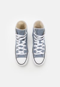 Höga sneakers i ljusblå canvas med vita snören, gummitoffel och svarta sulor. Har en texturerad finish och vadderad krage.