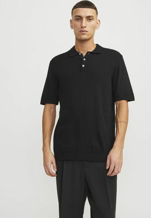 Zwarte polo met korte mouwen, gemaakt van gebreide stof. Heeft een kraagontwerp, een drie-knopen sluiting en ribbels aan de onderrand en mouwen.