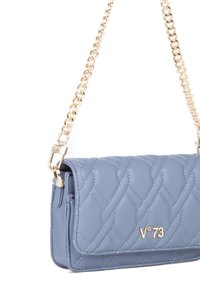 Gequilted, lichtblauw leren handtas met een gouden chain strap; beschikt over een logodetail en een strakke, rechthoekige vorm.