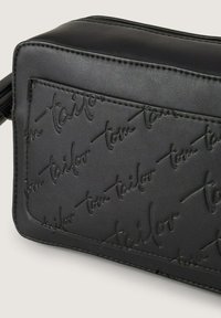 Borsa nera in pelle sintetica con logo "tom tailor" impresso, forma rettangolare, texture liscia e dettagli di cucitura a contrasto.